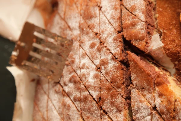 Bolo de close-up com açúcar em pó em estanho e espátula — Fotografia de Stock