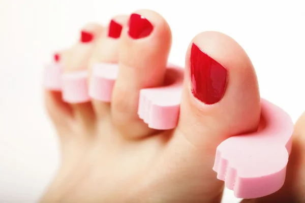 Pédicure du pied appliquant des ongles rouges sur du blanc — Photo