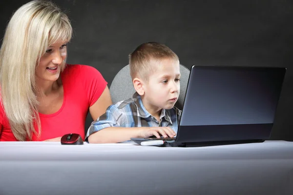 Mãe com filho olhando no laptop — Fotografia de Stock