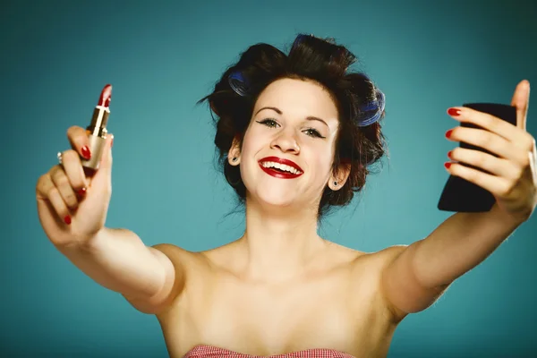 Girl in curlers styling hair applying make up — Stock Photo, Image