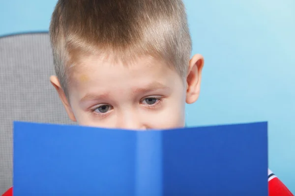 Junge Kind liest ein Buch über blau — Stockfoto