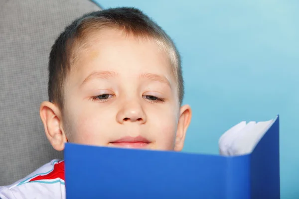 Junge Kind liest ein Buch über blau — Stockfoto