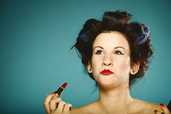 Girl in curlers styling hair applying make up — Stock Photo, Image