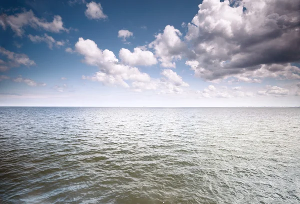 Céu azul nublado acima de uma superfície do mar — Fotografia de Stock