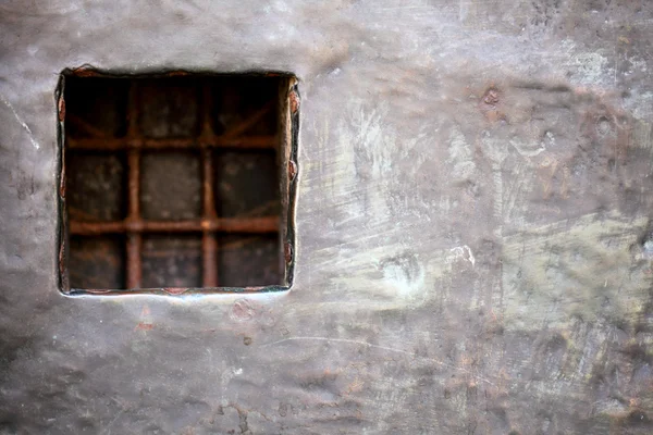 Окно ячейки с решеткой в серой металлической стене — стоковое фото