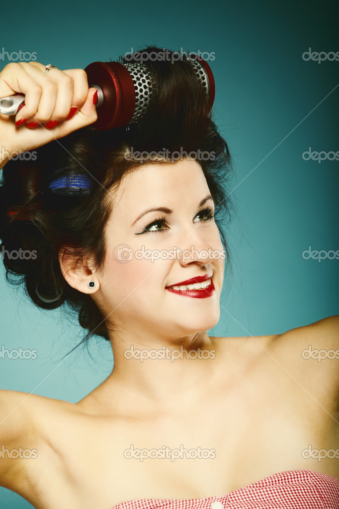 Girl in curlers with hairbrush styling hair Stock Photo by ©Voyagerix
