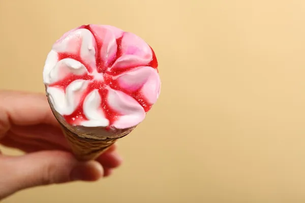 Berry icecream cone in hand on orange — Stock Photo, Image