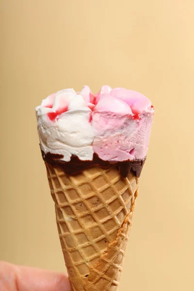 Berry icecream cone in hand on orange — Stock Photo, Image