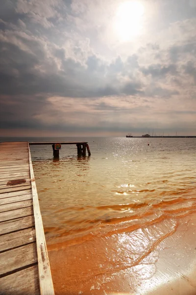 Old wooden pier at the sea sunrise or sunset — Stock Photo, Image