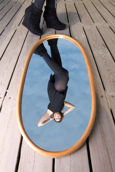 Doordachte vrouw met haar reflectie in spiegel — Stockfoto