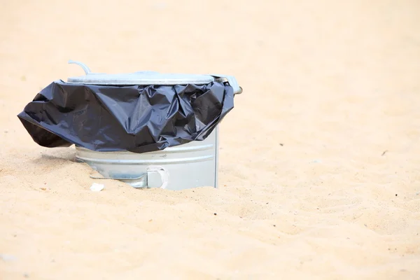 Корзина для мусора из серого металла или банка на пляже — стоковое фото