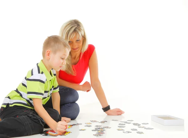 玩拼图游戏与她的儿子的母亲 — 图库照片