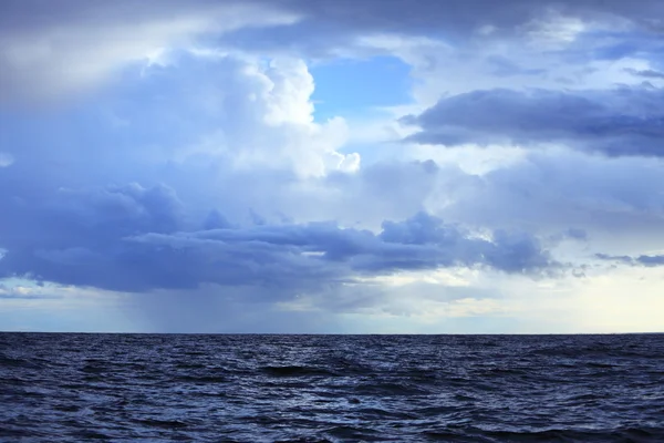 Nublado cielo oscuro sobre una superficie del mar — Foto de Stock