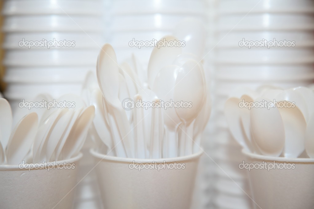 Disposable plastic utensils cups and spoons — Stock Photo © Voyagerix