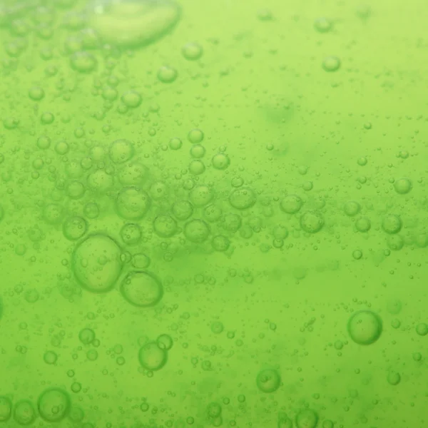 Bolle di sapone verde fondo liquido — Foto Stock