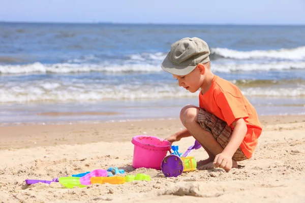 Jongen speelgoed spelen op strand — Stockfoto