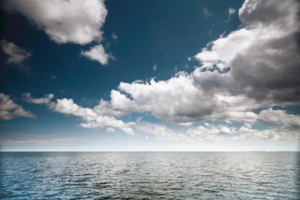 Céu azul nublado acima de uma superfície do mar — Fotografia de Stock