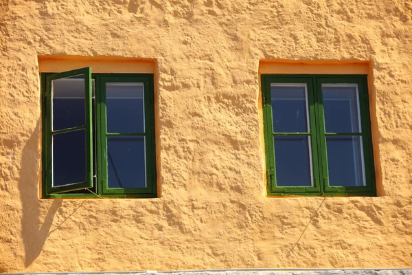 Janelas verdes na parede laranja — Fotografia de Stock