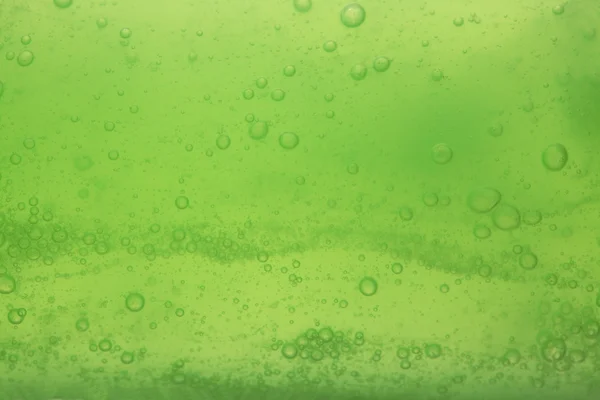 Bolle di sapone verde fondo liquido — Foto Stock