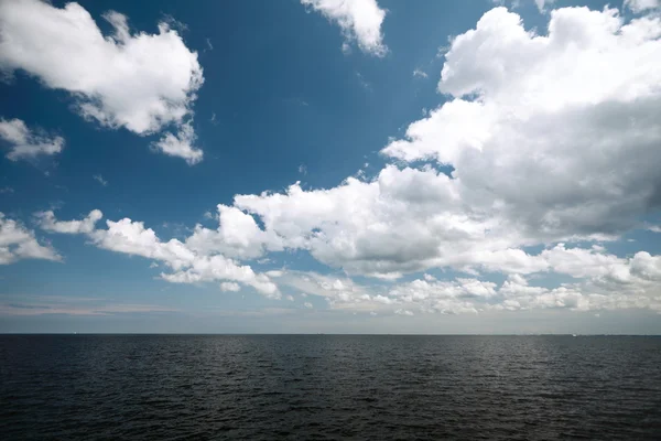 Céu azul nublado acima de uma superfície do mar — Fotografia de Stock