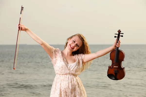 Счастливая блондинка со скрипкой на открытом воздухе — стоковое фото