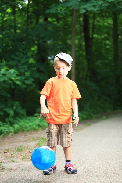 Ragazzo che gioca con la palla in parco all'aperto — Foto Stock