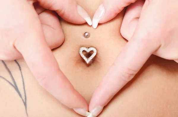 Hände Herz-Symbol um Nabelpiercing — Stockfoto