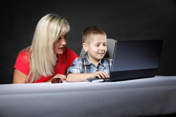 Mãe com filho olhando no laptop — Fotografia de Stock