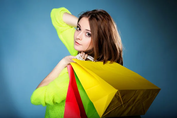Young woman with paper multi coloured shopping bag — Stock Photo, Image