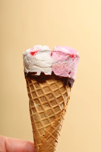 Berry icecream cone in hand on orange — Stock Photo, Image