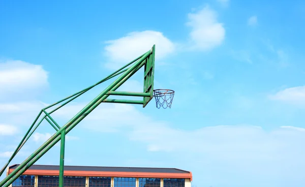 Basketbalový koš na zatažené obloze modré pozadí — Stock fotografie
