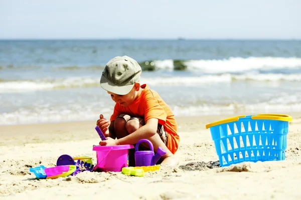 Niño jugando juguetes en la playa —  Fotos de Stock