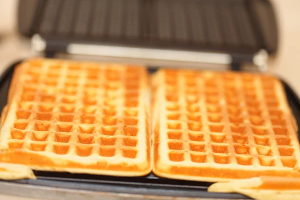 Waffle iron preparing waffles in kitchen — Stock Photo, Image