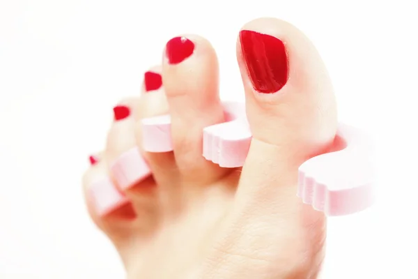 Πεντικιούρ ποδιών με κόκκινα νύχια στα λευκά — Φωτογραφία Αρχείου
