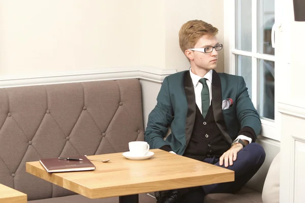 Joven hombre guapo y elegante en la cafetería con café —  Fotos de Stock