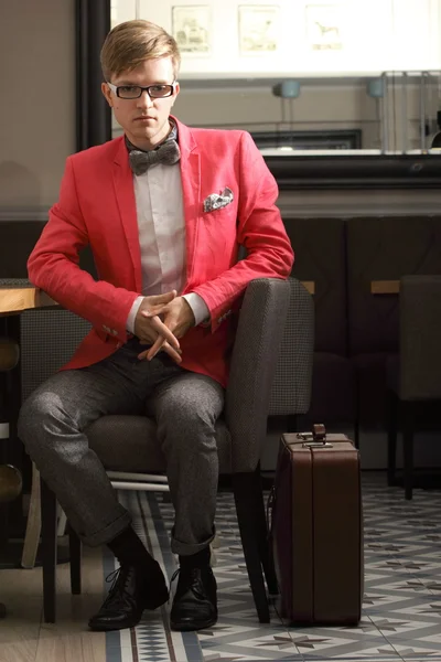Giovane bell'uomo elegante con valigia aspetta — Foto Stock