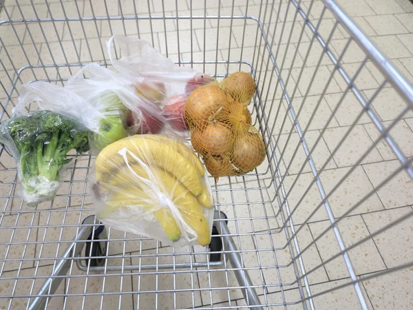 Shopping cart with grocery at supermarket — Stock Photo, Image