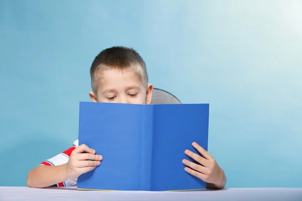 Junge Kind liest ein Buch über blau — Stockfoto