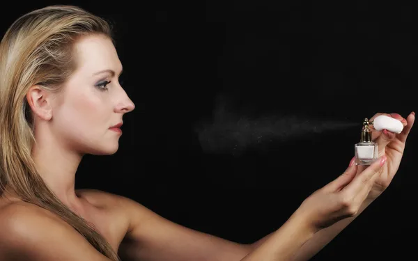 Portrait beautiful woman spraying perfume on black — Stock Photo, Image