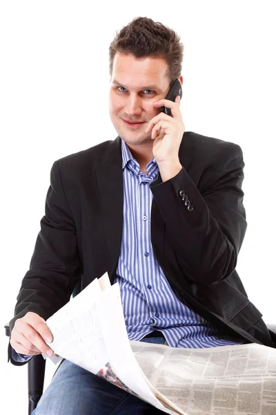 Man reads newspaper phoning - economy news — Stock Photo, Image