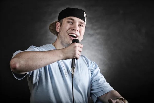Рэп-певец с микрофоном крутой жест рукой — стоковое фото