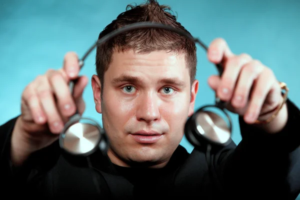 Música y tecnología, hombre sonriente ofreciendo auriculares —  Fotos de Stock