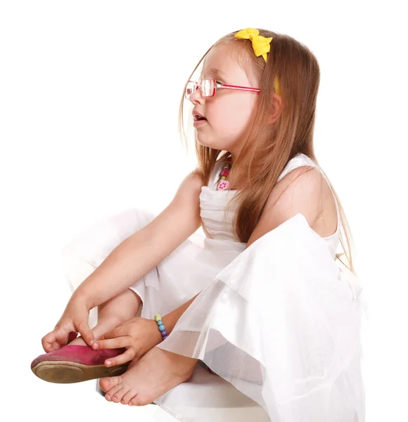 Child little girl tries to put on her shoes isolated — Stock Photo, Image