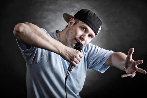 Rap zpěvák muž s chladnou ruku gestem mikrofon — Stock fotografie