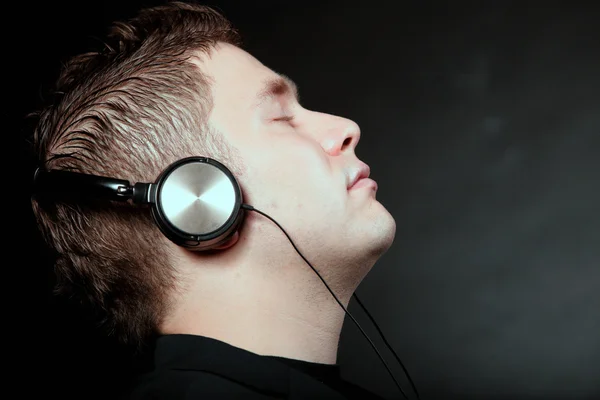 Jeune homme avec écouteurs écoutant de la musique — Photo