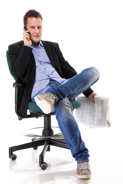 Man reads newspaper phoning - economy news — Stock Photo, Image
