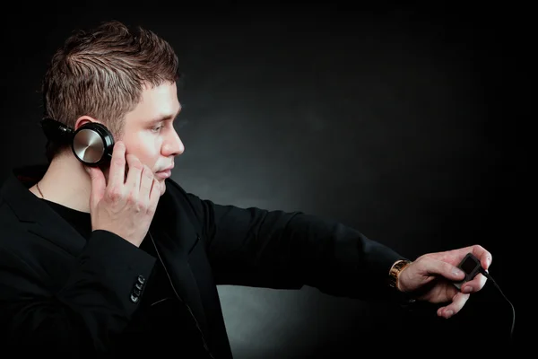 Junger Mann mit Kopfhörer benutzt MP3-Player — Stockfoto