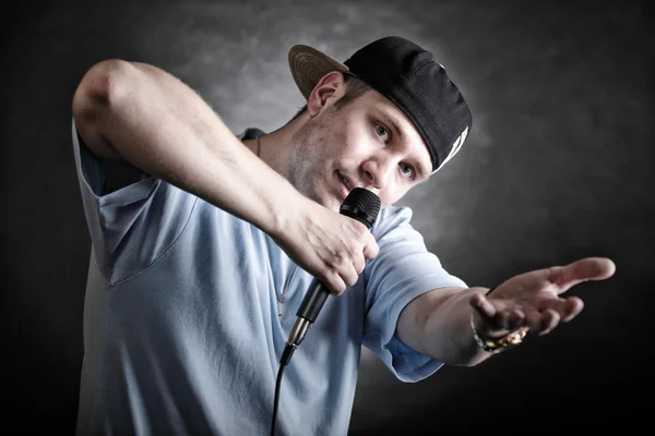 Rap piosenkarka człowiek z mikrofonem nieugięty gest — Zdjęcie stockowe