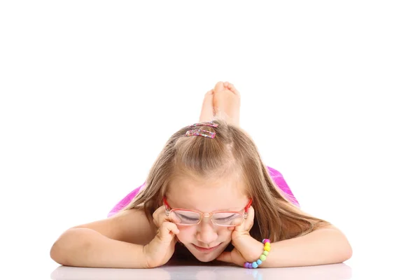 Linda niña tendida en el suelo haciendo diversión aislada — Foto de Stock