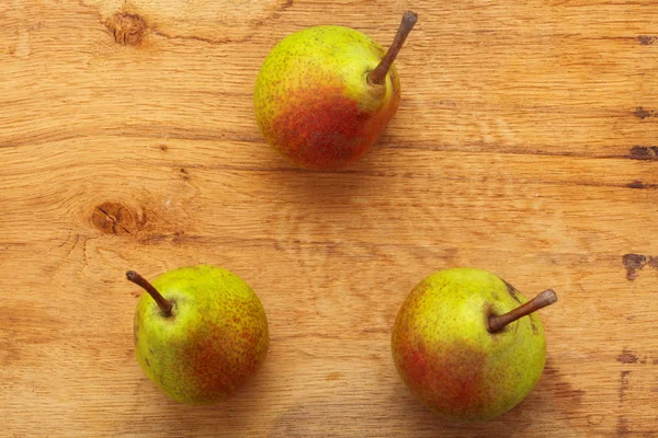 Τρεις αχλάδια φρούτα σε ξύλινο τραπέζι φόντο — Φωτογραφία Αρχείου